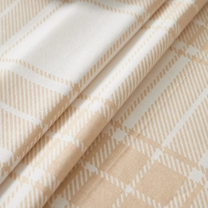 Close-up of brown plaid linen tablecloth fabric showing fine woven texture and soft folds