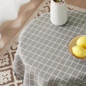 Minimalist grey plaid cotton linen tablecloth with tassel edges on a dining table