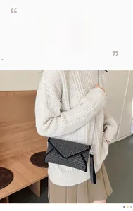 Détail de la pochette enveloppe noire ornée de strass argentés et bandoulière chaîne