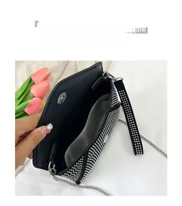 Détail du sac enveloppe noir en strass montrant les compartiments et la bandoulière chaîne