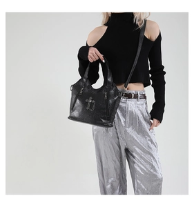 Detail of gothic black leather tote with silver cross, chains and litchi texture