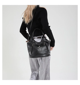 Detail of crossbody tote bag with gothic silver cross and textured black leather