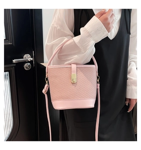 Detail of pink bucket bag with twill weave texture and golden twist lock closure