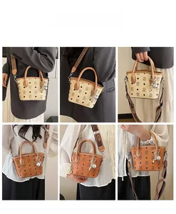 Vue détaillée du sac seau en cuir à monogramme avec bandoulière tissée et accessoires
