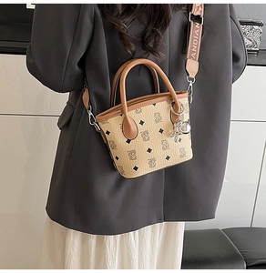 Détail du sac seau bandoulière avec logo ours, motif losange et sangle tissée