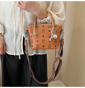 Vue détaillée du sac seau marron à monogramme avec motifs d'ours et large bandoulière