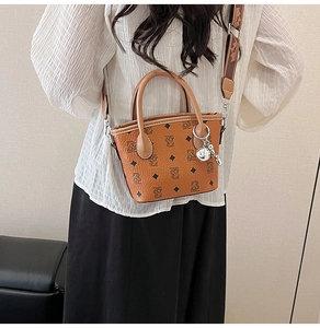 Détails de ce sac seau marron à motifs d'ours avec pendentif boule argentée élégant
