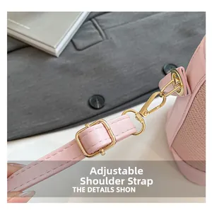 Détail de la bandoulière réglable en cuir rose avec mousqueton doré et finitions