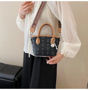 Détail du sac seau gris avec poignées brunes et large bandoulière en jacquard tissé