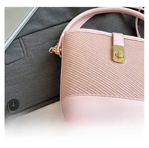 Gros plan du sac seau rose tissé avec bordure en cuir et fermoir en métal doré
