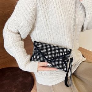 Pochette enveloppe noire élégante avec strass argentés et bandoulière montrée sur mannequin