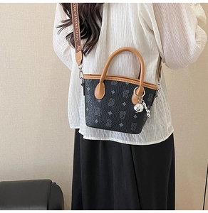 Détail du sac seau gris avec imprimé ours et large bandoulière tissée lettrée