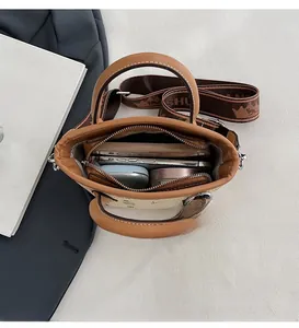 Vue de dessus du sac seau en cuir marron montrant l'intérieur spacieux et la bandoulière