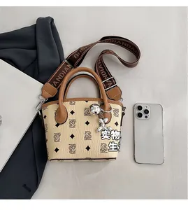 Vue de dessus d'un mini cabas en cuir beige avec motif ours et large bandoulière