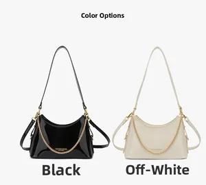 Detail view of glossy patent leather bucket bags in black and off-white with gold chains