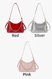 Three shiny bucket bags in red, silver, and pink with gold chains and fashion logo