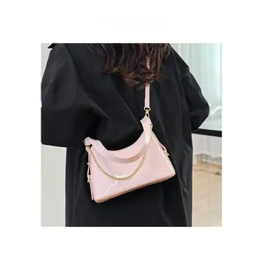 Pink patent leather tote bag detail with gold metal chain and adjustable leather strap