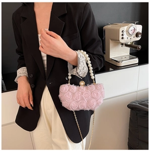 Close-up of pink evening box bag with 3D rose flowers, pearl handle and gold chain