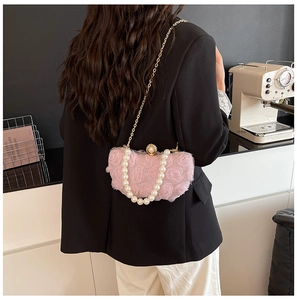 Detail of pink floral chiffon clutch with pearl handle and golden chain on model
