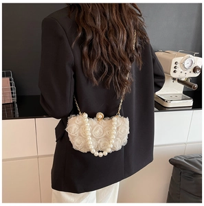 Detail of white 3D chiffon floral evening bag with pearl handle and gold chain strap