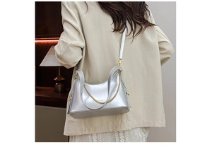 Detail of silver mirror leather shoulder bag with gold chain and Fashion Bags text
