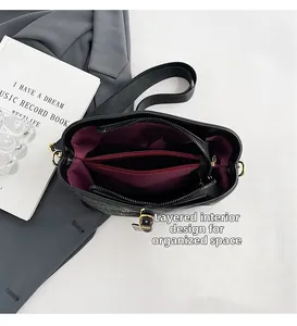 Interior view of black bucket bag with wide strap and multi-layer organized compartments