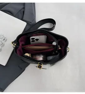 Detailed top view of large black bucket bag interior with purple lining and zip compartment