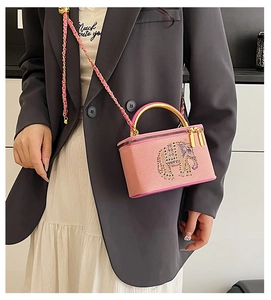Detailed view of pink leather mini box bag with colorful rhinestone elephant pattern