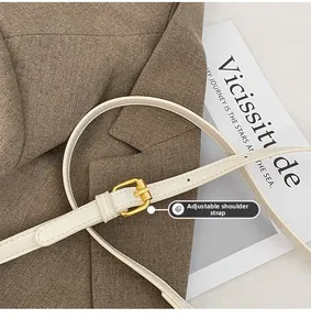 Detail of adjustable white PU shoulder strap with gold buckle on luxury minimalist bag