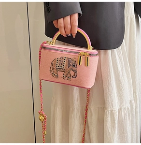 Close-up of pink box bag with sparkling rhinestone elephant and woven chain strap