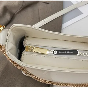 Detail of smooth gold zipper and white patent leather on the luxury chain bucket bag