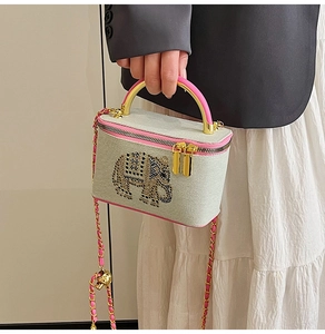 Detail of a pink box bag with a rhinestone elephant pattern and gold chain strap