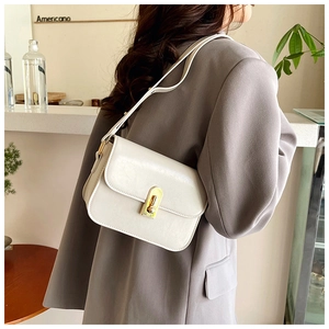 Model view of a minimalist white faux leather shoulder bag with a gold twist lock detail