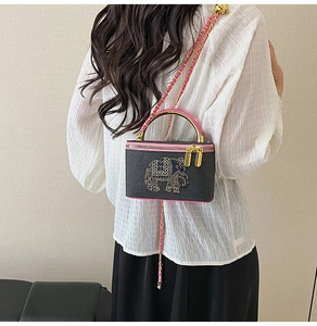 Detail of crossbody box bag with elephant embroidery and pink chain strap