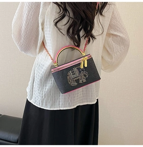 Detail of denim box bag with rhinestone elephant and pink leather trim and chain strap