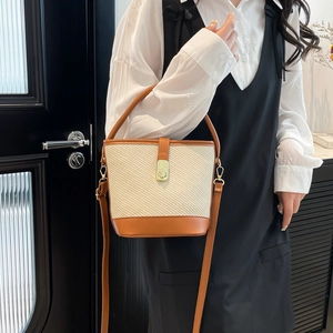 Sac seau bicolore chic avec texture tressée beige et cuir marron avec fermoir doré élégant