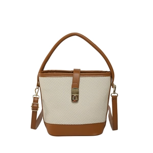 Sac seau tissé beige chic avec garniture en cuir marron et fermoir en métal doré