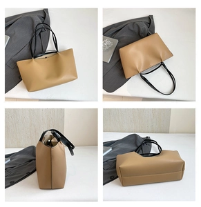 Detail view of khaki large capacity commute tote bag with black straps and smooth leather texture