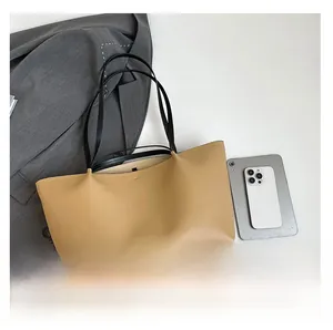 Top view of large beige leather tote bag with black handles showing spacious interior