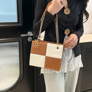 Brown and white checkered crossbody bag with gold chain strap on model