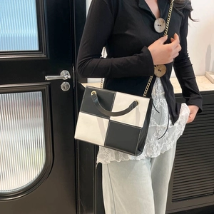 Minimalist black and white contrast leather crossbody bag with elegant gold chain strap
