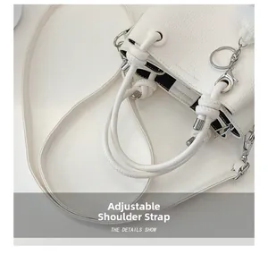 Detail of white litchi pattern leather bucket bag with adjustable knotted strap design