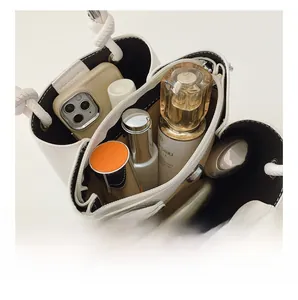 Top view of multi-compartment white bucket bag showing inner capacity and knot handle