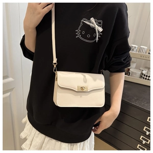 Vue détaillée d'un sac bandoulière carré beige vintage avec fermoir rotatif doré