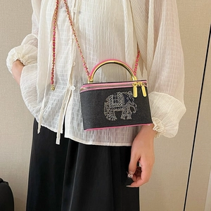 Fashionable chain box bag with rhinestone elephant and pink trim on a female model