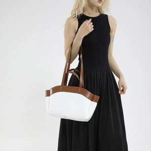 Minimalist white leather bucket bag with brown trim and H-shaped metal buckle detail
