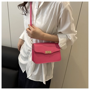 Détails du sac fuchsia avec fermoir rotatif doré et structure en accordéon multicouche