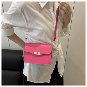 Détail du sac bandoulière rectangulaire rose néon avec fermoir rotatif doré en cuir