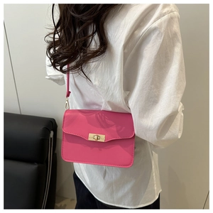 Détail du sac bandoulière rose fuchsia avec bord festonné et fermoir rotatif doré élégant