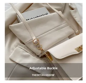 Détail de la boucle métallique réglable et du cuir PU crème sur un sac à bandoulière